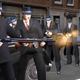 A gang of well-dressed mobsters line up single file and fire at some unsuspecting schmuck.